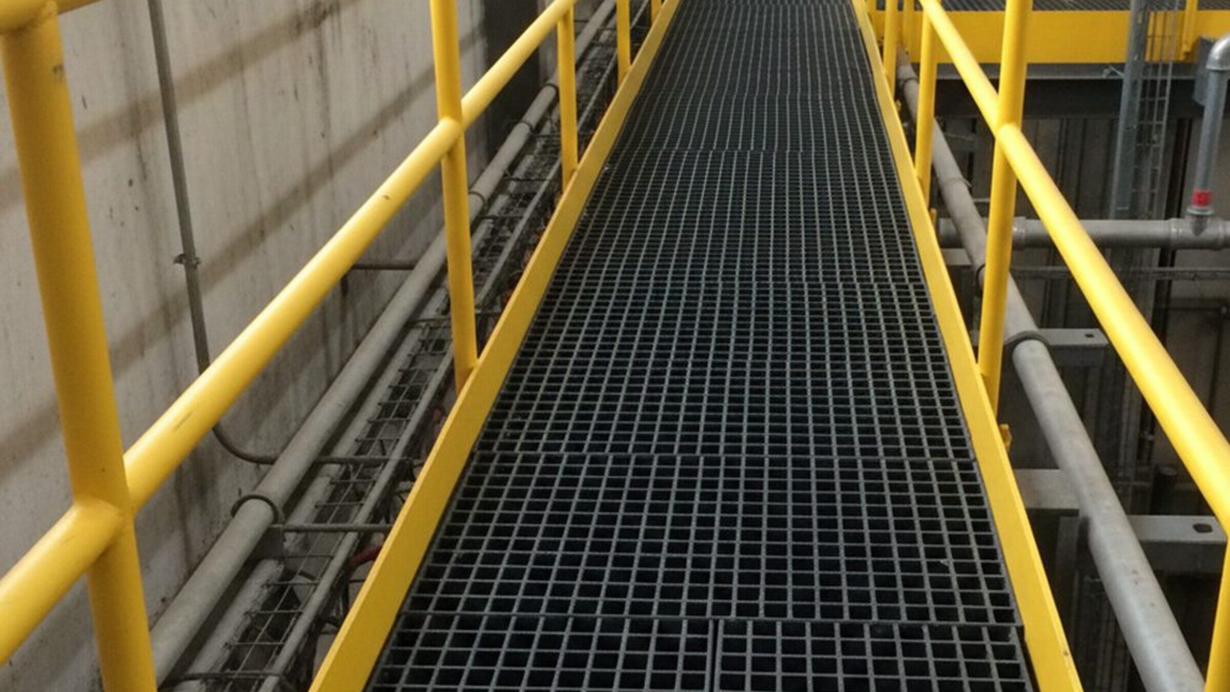 Yellow and black GRP grating walkway with an anti-slip surface